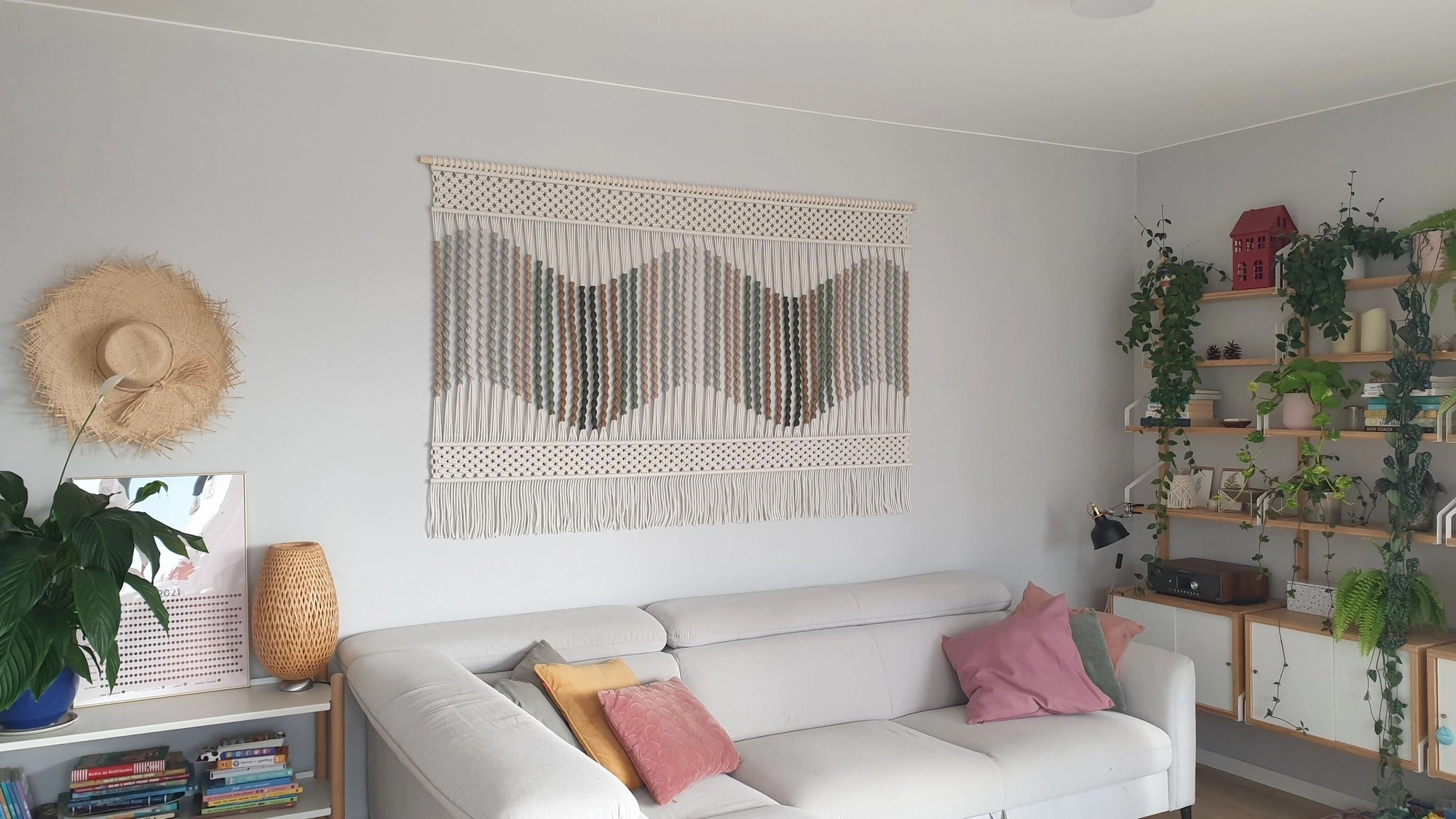 Duża ręcznie wykonana makrama ścienna NORDART w przytulnym salonie. Minimalistyczna dekoracja z naturalnych materiałów pasująca do wnętrz w stylu japandi, nowoczesnym, boho oraz eklektycznym, autorski projekt podkreślający spokojny charakter przestrzeni.