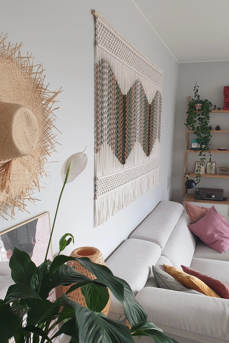 Nowoczesne, przytulne wnętrze salonu z dekoracją ścienną w formie makramy NORDART. Ręcznie wykonana ozdoba z naturalnych materiałów wpisująca się w styl japandi, nowoczesny i boho, tworząca spokojny, harmonijny klimat.